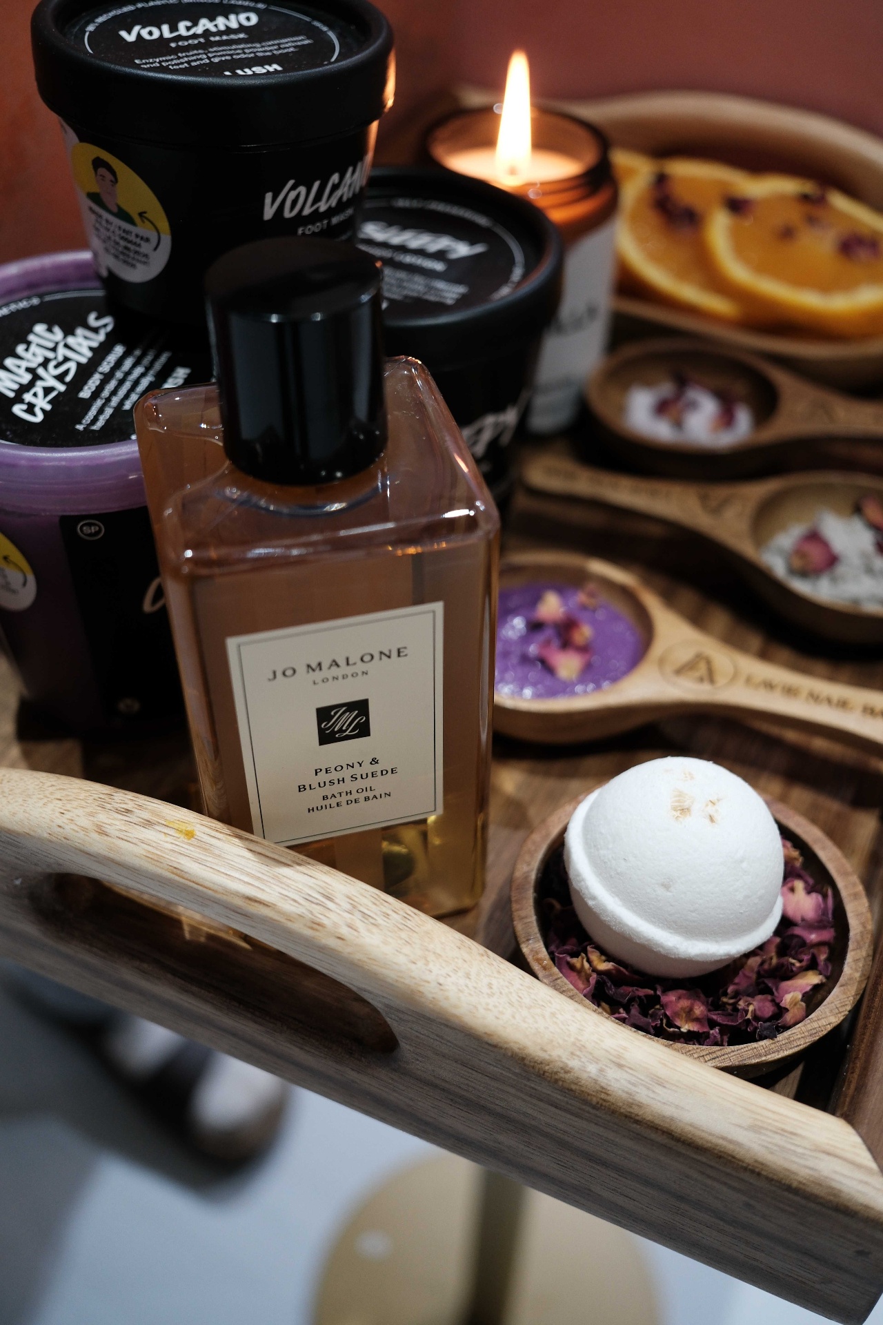 Close-up of the signature Lavie pedicure tray with Jo Malone Peony bath oil, Lush products, and rose bath bomb